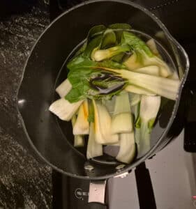 Pak Choi in the pan with a splash of soy sauce