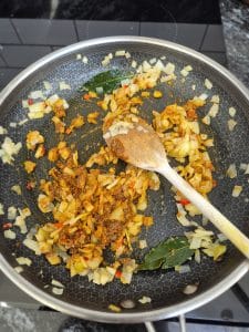 Ad spices to the mix in the pan