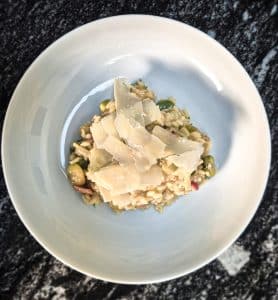 Broad bean risotto with bacon in a bowl